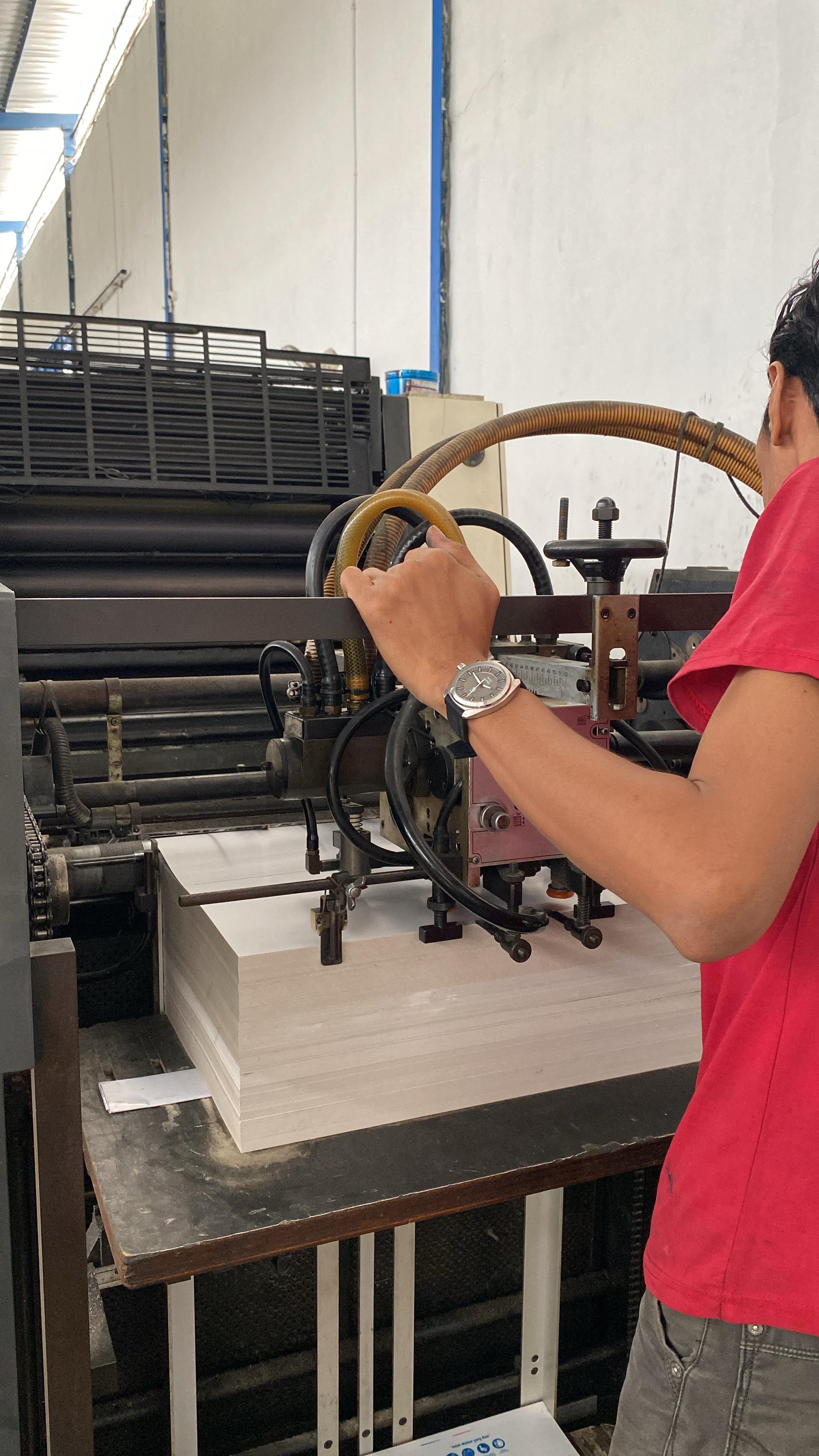 Operator mengatur mesin cetak